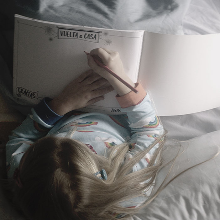 Fotografía de una niña dibujando en el Cuaderno de dibujo TostaRica desde la cama de un hospital