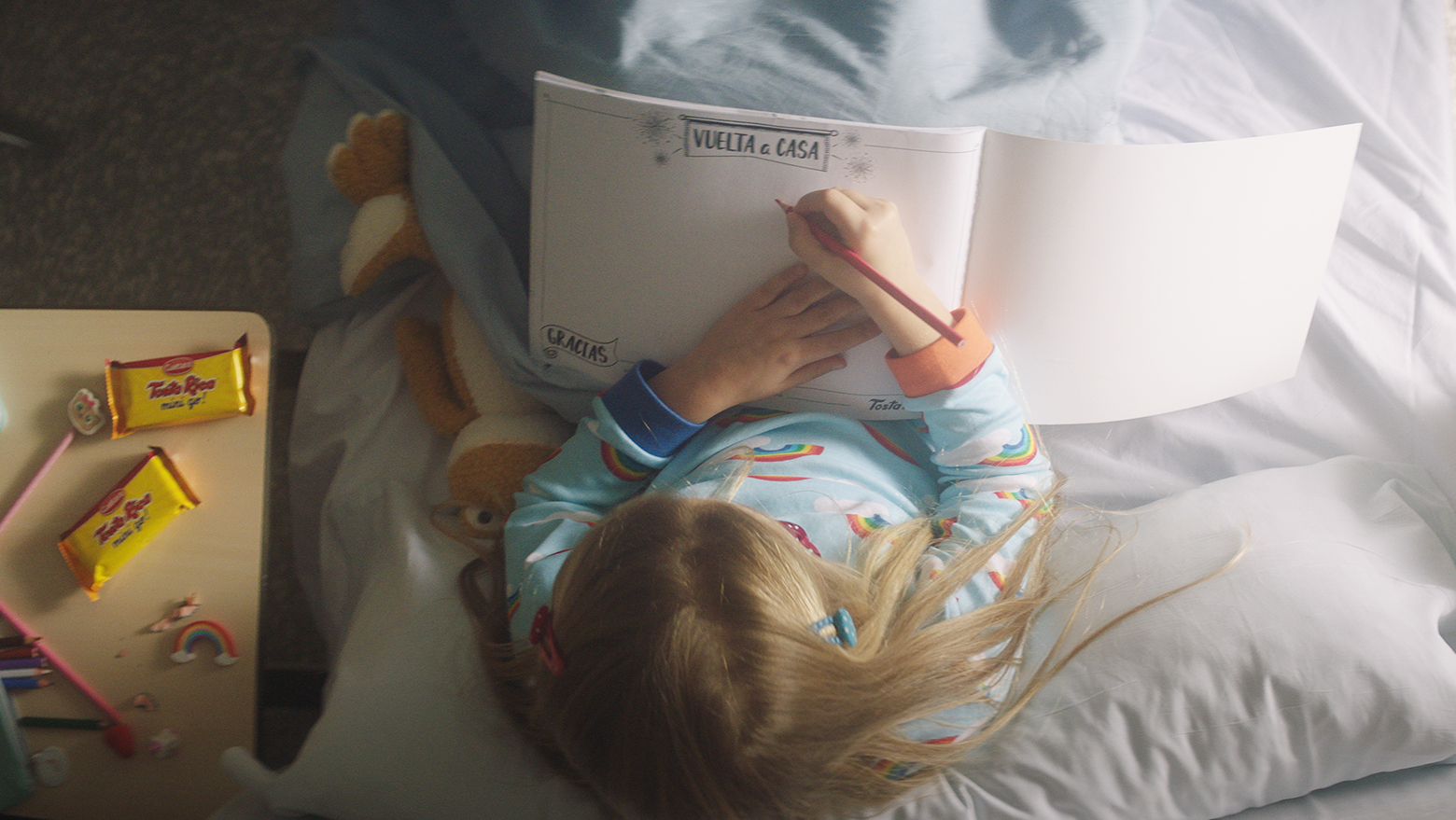 Photo of a girl drawing in the TostaRica drawing notebook from a hospital bed